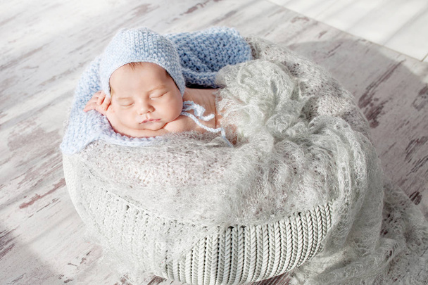 Sweet newborn baby sleeps.  Newborn boy folded handles  in a basket - Fotoğraf, Görsel