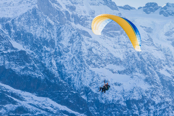Sporty ekstremalne w Alpach. Tandem paralotniarstwo nad górami w dolinę Lauterbrunnen, Szwajcaria - Zdjęcie, obraz