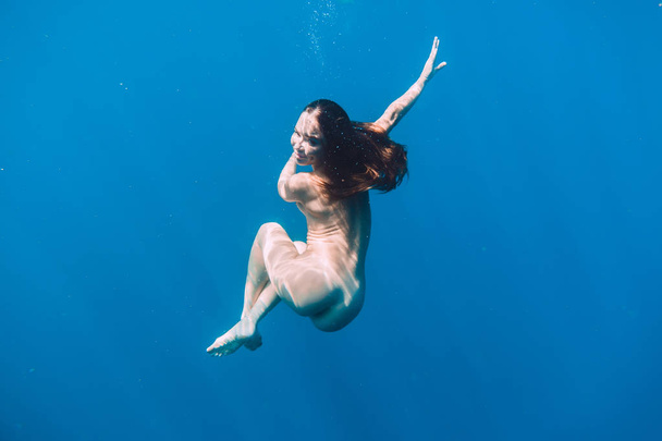 Kaunis alaston nainen kelluva vedenalainen sininen valtameri
 - Valokuva, kuva