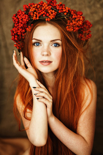 red-haired girl with gorgeous long hair and blue eyes in a wreath of Rowan on her head - Foto, Imagem