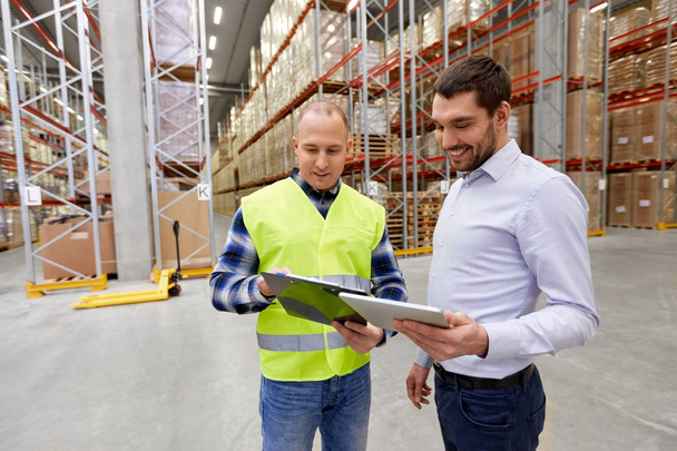 worker and businessman with tablet pc at warehouse - Foto, Imagem