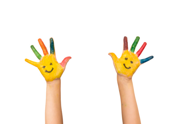 Glimlach, geluk en leuk concept. Gelukkig kind toont geschilderde handen met kleurrijke verf en lachende gezichten. Kind met kleurrijke palmen lachen. Tiener heeft plezier en geniet van creativiteit. Geïsoleerd op witte achtergrond. - Foto, afbeelding