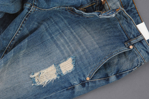 Teil der beschädigten Jeanshose mit Tasche und aufgeknöpftem Reißverschluss, Nahaufnahme - Foto, Bild
