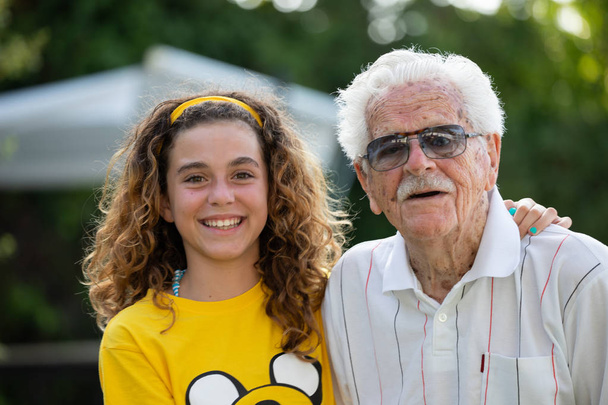 Porträt eines über 100-jährigen Urgroßvaters und seiner 10-jährigen Urenkelin - Foto, Bild