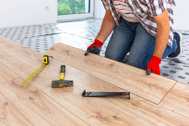 Handyman installing new laminated wooden floor - Photo, image