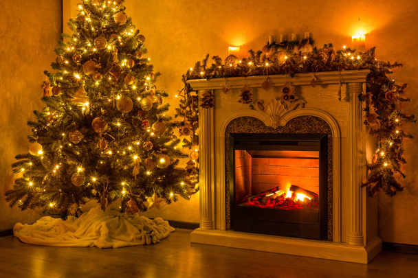 New Year's Eve. Happy new year and christmas. A cozy room where a fireplace burns and there is a Christmas tree decorated with toys and a garland. The room is lit by Christmas garlands. 2019 year - Photo, Image