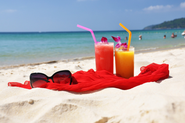 Coppia di frullati di frutta, scialle rosso e occhiali da sole sulla b tropicale
 - Foto, immagini