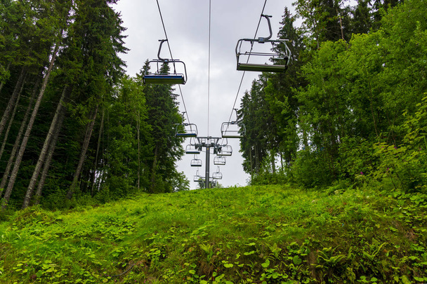 Skilift in den verregneten Sommerbergen durch herrlichen Bergwald in den ukrainischen Karpaten - Foto, Bild