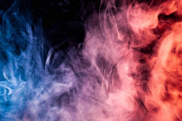 Wolke aus rotem, blauem und weißem Rauch auf schwarzem Hintergrund. Hintergrund aus dem Rauch des Vaps - Foto, Bild