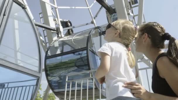 Mutter und Tochter schauen mit erhobenem Kopf auf das Riesenrad - Filmmaterial, Video