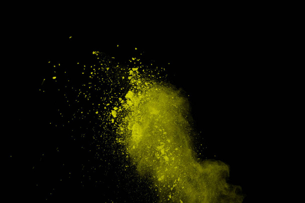 Abstract of yellow powder explosion on black background. Yellow powder splatted isolate. Colored cloud. Colored dust explode. Paint Holi. - Fotó, kép