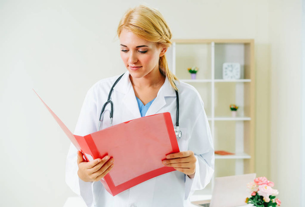 Young female doctor working in hospital office. Medical and healthcare concept. - 写真・画像