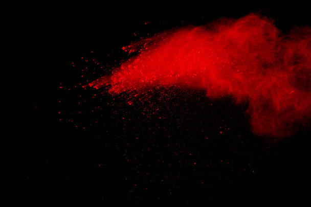 Abstract van rode poeder explosie op zwarte achtergrond. Rode poeder splatted isoleren. Gekleurde wolk. Gekleurde stof exploderen. Verf Holi. - Foto, afbeelding