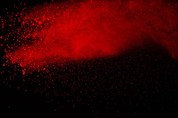 Zusammenfassung der Explosion von rotem Pulver auf schwarzem Hintergrund. rotes Pulver gespritzt isolieren. Farbwolke. Farbstaub explodiert. Farbholi. - Foto, Bild