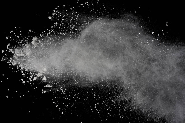 Λευκή σκόνη έκρηξη απομονώνονται σε μαύρο φόντο. Χρωματιστά σκόνη συντριφθούν. - Φωτογραφία, εικόνα