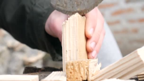 ręce młodego człowieka przytrzymaj ax i cięcia drewna - Materiał filmowy, wideo
