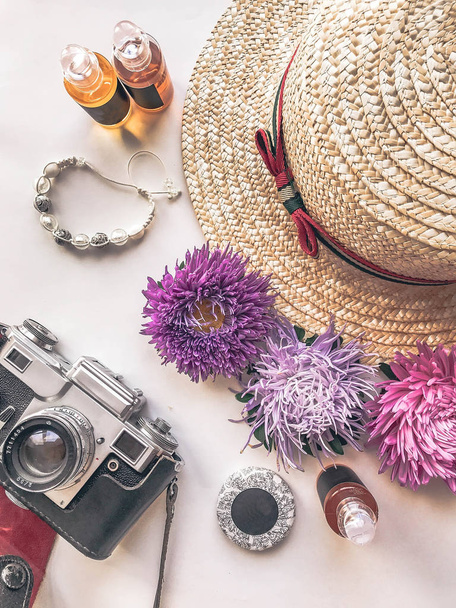 Stylized feminine flatlay with camera, hat, bunch of aster, bracelet mock up isolated on white top view. Woman accessories from above. Group Objects - Photo, Image