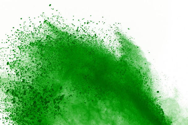 Freeze beweging van groen poeder exploderen op witte achtergrond. - Foto, afbeelding