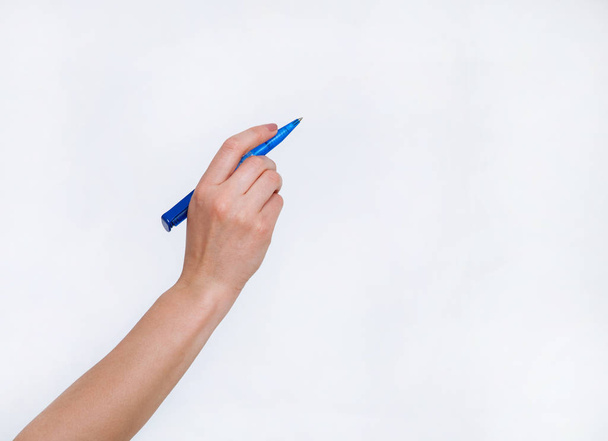 Human hand holding blue ball pen, white background - Фото, зображення