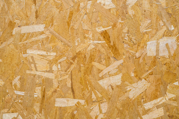 close-up geperste houten plaat achtergrond, naadloze textuur van georiënteerde strand board - OSB hout. - Foto, afbeelding