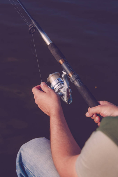 Un uomo pescatore prende un pesce. Pesca, filatura bobina, pesce, fiume
 - Foto, immagini