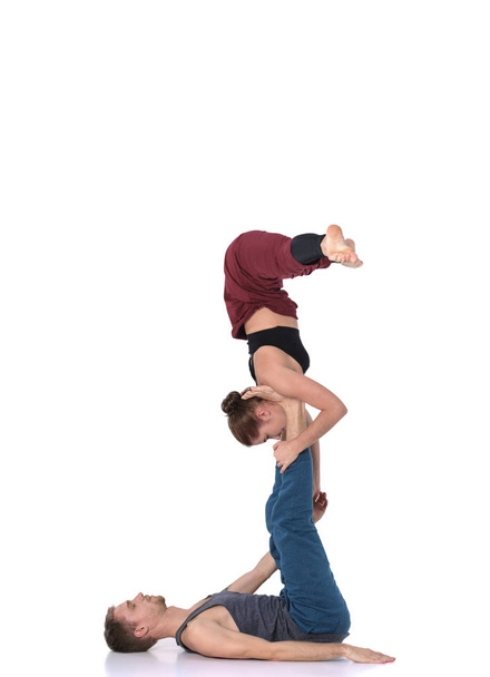 Young athletic couple practicing acroyoga. Balancing in pair. - Foto, Imagen