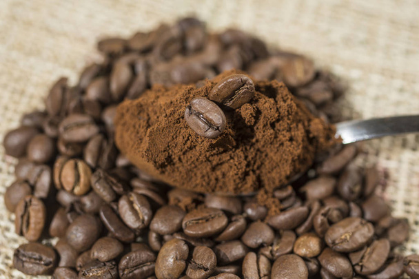 Macro of a coffee bean in roasted coffee grounds. - Fotografie, Obrázek