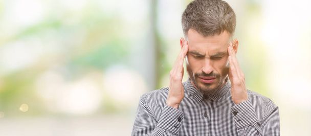 Young hipster man with hand on head for pain in head because stress. Suffering migraine. - Photo, Image