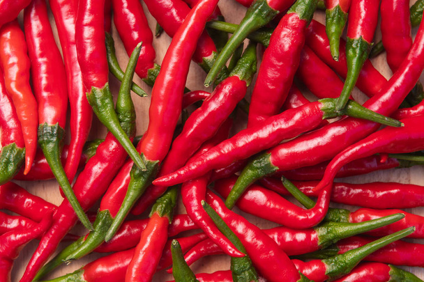 Fresh red hot thai chili peppers on wooden surface - Foto, imagen
