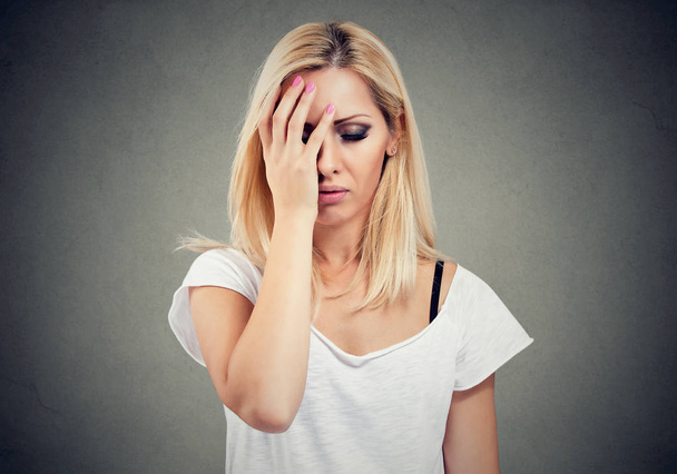 Casual young woman having problems and looking worried with stressed face expression on gray background.  - Photo, Image