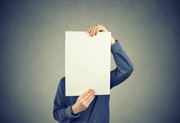 Man holding blank piece of paper hiding his face - Foto, Bild