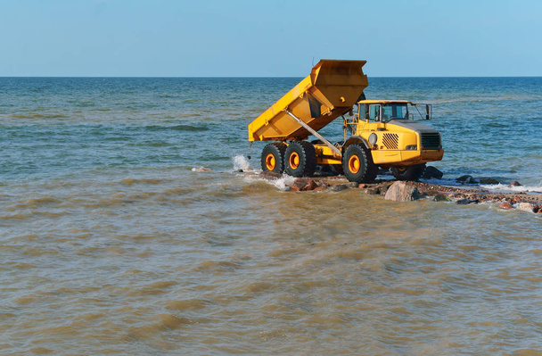 equipo de construcción en la orilla, la construcción de rompeolas, medidas de protección costera
 - Foto, Imagen