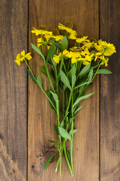 Bouquet with yellow flowers on wooden table - Foto, imagen