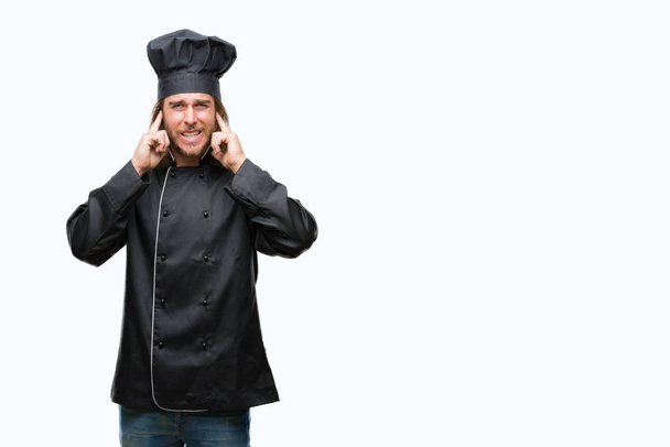 Young handsome cook man with long hair over isolated background covering ears with fingers with annoyed expression for the noise of loud music. Deaf concept. - Photo, Image