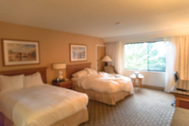 verschwommenes typisches Doppelzimmer mit Fenstern in amerikanischem Hotel - Foto, Bild