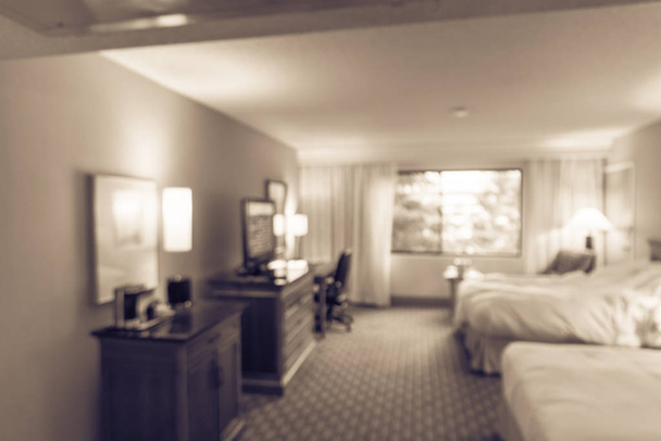 Vintage tone motion blurred typical double room with windows, flat-screen TVs in American hotel - Photo, Image