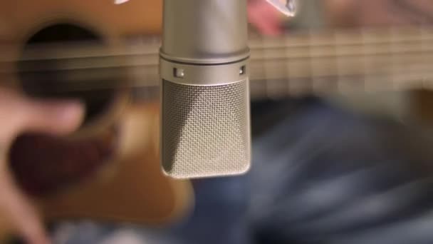 Hombre en el estudio de música tocando la guitarra, enfoque selectivo en el micrófono
 - Metraje, vídeo