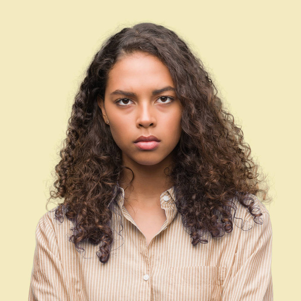 Young hispanic business woman skeptic and nervous, disapproving expression on face with crossed arms. Negative person. - Photo, Image