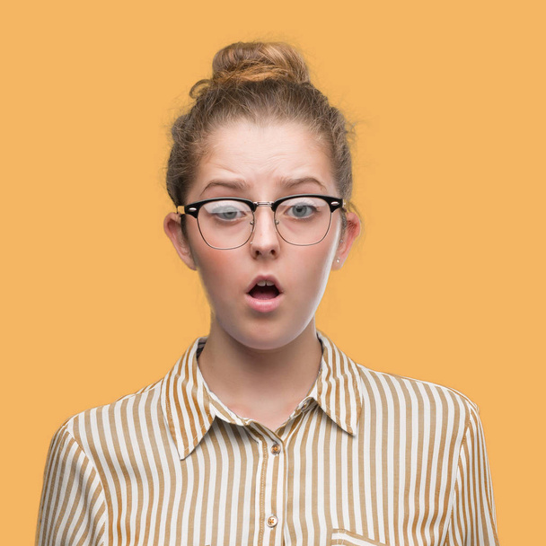 Young blonde business woman afraid and shocked with surprise expression, fear and excited face. - Photo, Image