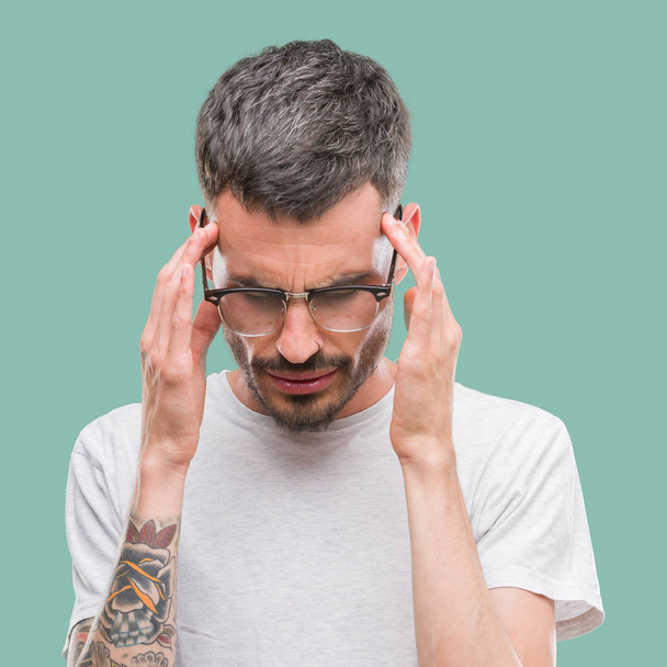 Jeune homme adulte tatoué avec la main sur la tête pour la douleur à la tête parce que le stress. Migraine souffrante
. - Photo, image