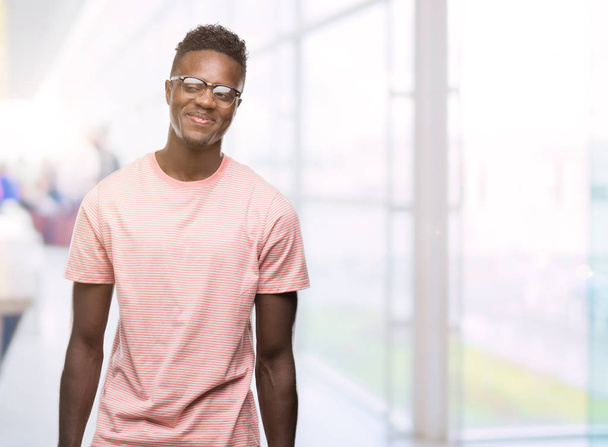 Giovane uomo afroamericano indossa rosa t-shirt sorridente guardando lato e fissando via pensando
. - Foto, immagini