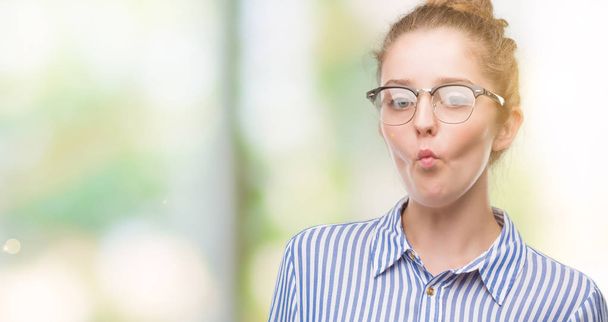Jeune femme d'affaires blonde faisant visage de poisson avec des lèvres, geste fou et comique. Drôle d'expression
. - Photo, image