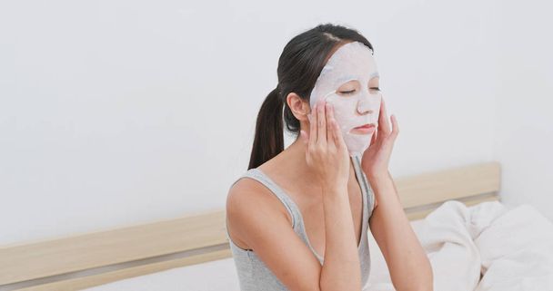 Woman apply paper mask on bed - Fotografie, Obrázek
