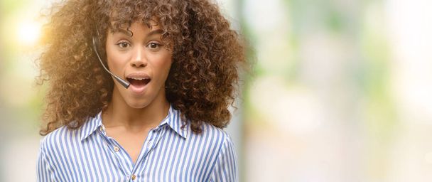Αφρικανική αμερικανική κλήση κέντρο χειριστή γυναίκα φοβάται το σοκ με πρόσωπο έκπληξη, φοβάται και ενθουσιασμένος με φόβο έκφραση - Φωτογραφία, εικόνα