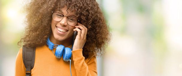 African american student woman happy talking using a smartphone mobile phone - 写真・画像