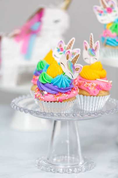 Μονόκερος cupcakes με πολύχρωμη buttercream κερασάκι στην τούρτα περίπτερα. - Φωτογραφία, εικόνα