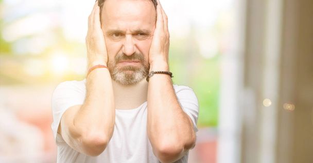 Zraněné starší muž použitím fixační límec, pokrývající uši ignorovat obtěžující hluk, zapojuje uši, aby se zabránilo vnímání zvuku. Hlučná hudba je problém. - Fotografie, Obrázek