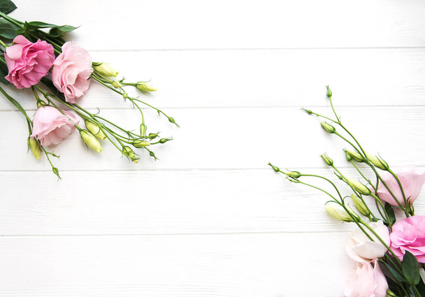 木製の背景に新鮮なピンクのトルコギキョウの花のフレーム - 写真・画像
