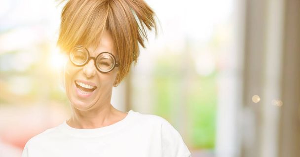 Hullu keski-ikäinen nainen yllään hassut lasit luottavainen ja onnellinen iso luonnollinen hymy nauraa
 - Valokuva, kuva