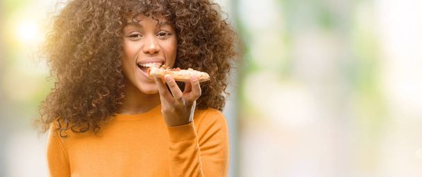 Afrikai-amerikai nő egy pizza szelet, a gondolkodás súlyos Szúró Szembenéz magabiztos kifejezés - Fotó, kép
